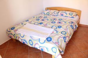 łóżko z kolorową kołdrą i torbą w obiekcie Apartments Todorovic w Petrovacu na Moru