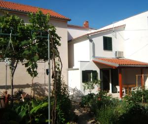 a house with a garden in front of it at Apartmani Stipanelo in Murter