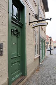 una puerta verde al lado de un edificio en Apartments am Brunnen en Quedlinburg