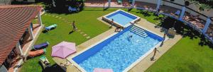 an overhead view of a swimming pool with people and umbrellas at Quinta Dos Amarelos no Meco in Aldeia do Meco