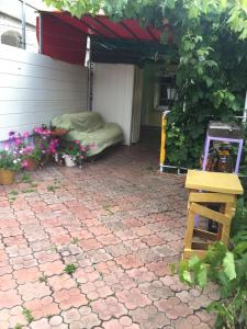 a patio with a bed and a table and flowers at Holiday house near sea on Lvovskaya in Odesa