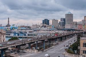 a city with a bridge over a street with cars at New Alexander Hotel in Genova