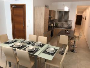 Azure Cottage في Żebbuġ: طاولة طعام وكراسي في مطبخ