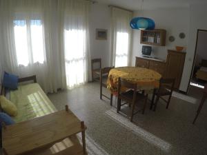 a living room with a table and a couch and a kitchen at Casa Francesca - Agenzia Cocal in Caorle