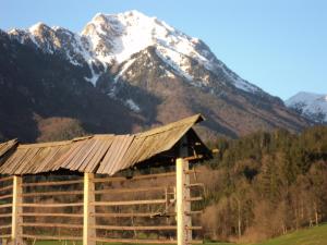 a snow covered mountain in the background of a cabin at Pr'Simi in Golnik