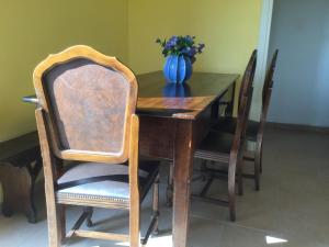 Casa Luisa في بالاتزو: طاولة غرفة طعام خشبية مع مزهرية زرقاء من الزهور
