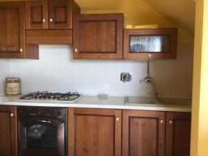 uma cozinha com armários de madeira e um forno com placa de fogão em Casa Luisa em Palazzo