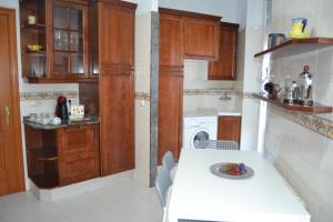 una cocina con armarios de madera y una mesa blanca en Placido Apartment, en Manresa