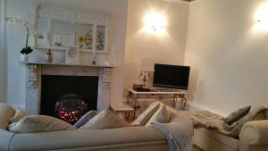 a living room with a couch and a fireplace at Madge House Ashbourne in Ashbourne