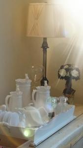 a table topped with white dishes and a lamp at Madge House Ashbourne in Ashbourne
