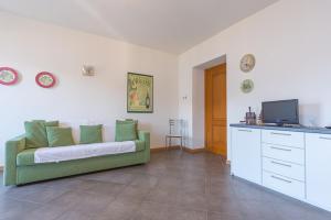 a living room with a green couch and a tv at Casa Amarilla in San Siro