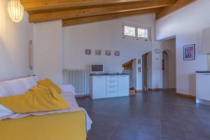 a living room with a yellow couch and a kitchen at Casa Amarilla in San Siro