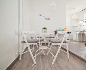 Un comedor blanco con una mesa y sillas. en B&B Lost in Rome, en Roma