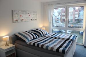 a bedroom with a couch and a large window at Ferienhaus Hafenzeit in Cuxhaven