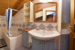 ein Badezimmer mit Waschbecken, Spiegel und Badewanne in der Unterkunft M house luxury suites in Lixouri