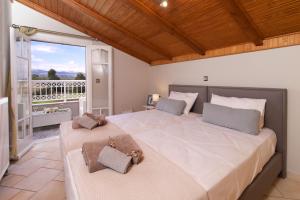 2 Betten in einem Schlafzimmer mit Balkon in der Unterkunft M house luxury suites in Lixouri