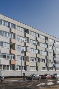 a large apartment building with cars parked in front of it at Grodzka Apartament Centrum in Słupsk