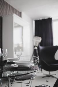 a dining room table with a plate and wine glasses at Grodzka Apartament Centrum in Słupsk