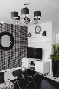 a living room with a table and a clock on the wall at Grodzka Apartament Centrum in Słupsk