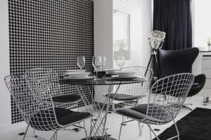 a dining room with a table with chairs and wine glasses at Grodzka Apartament Centrum in Słupsk