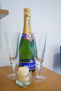 Una botella de champán y dos copas en una mesa. en Vico IV, en Gaeta
