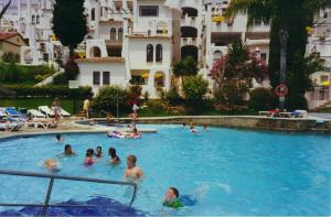 grupa ludzi pływających w basenie w obiekcie Pueblo Evita apartment in exclusive holiday complex w mieście Benalmádena