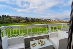 ein Balkon mit zwei Stühlen und einem Tisch und einer Aussicht in der Unterkunft M house luxury suites in Lixouri