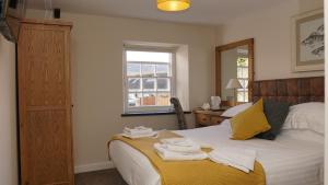 1 dormitorio con 1 cama con toallas en The Horseshoe Inn, en Crickhowell