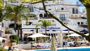 hotel z basenem z parasolami i budynkiem w obiekcie Pueblo Evita apartment in exclusive holiday complex w mieście Benalmádena