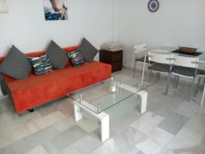 ベナルマデナにあるPueblo Evita apartment in exclusive holiday complexのリビングルーム(赤いソファ、テーブル付)