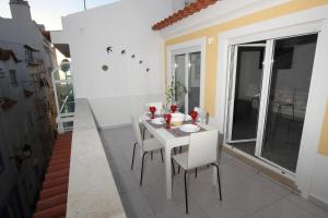 a white dining room with a white table and chairs at Ferhouse Dreams in Nazaré