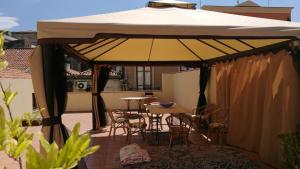 ein großer Sonnenschirm auf einer Terrasse mit Tisch und Stühlen in der Unterkunft Piccolo Casale in Milazzo