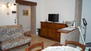 un soggiorno con divano e TV a schermo piatto di B&B La Casa Rosa a Balze