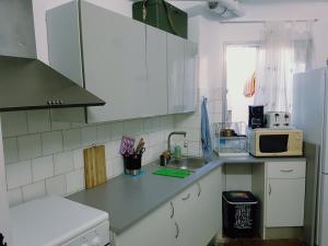 a kitchen with a sink and a microwave at Habitación cerca del centro in Valencia