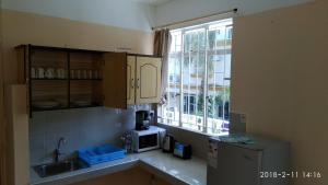 a kitchen with a sink and a microwave and a window at Alpha Villa - Studios without kitchen in Flic-en-Flac +18 photos