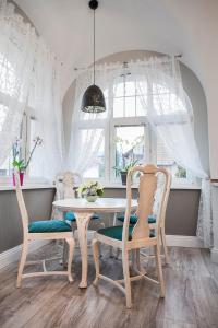 Cherry House Apartments في بيدغوشتش: غرفة طعام مع طاولة وكراسي ونافذة