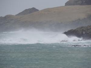 a wave in the ocean next to a mountain at Number 13 in Lerwick