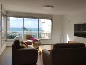 a living room with two couches and a view of the ocean at Nitza Boutique Apartment Kosher in Netanya