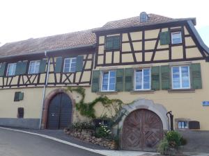 ein altes Haus mit zwei Türen und einem Tor in der Unterkunft Le voyage d'UBUNTU in Heiligenstein
