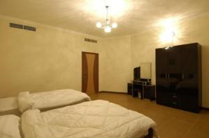 1 dormitorio con 2 camas y vestidor en Ramee Suite Apartment 4, en Manama