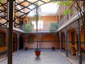 un cortile vuoto di un edificio con alberi in vaso di Apartamento El Barranco a Siviglia