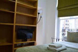 a bedroom with a tv and a bed and a tvicterictericterictericter at Studios2Let - North Gower in London