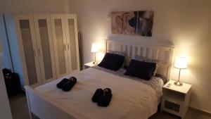 sypialnia z łóżkiem z dwoma czarnymi kapciami w obiekcie Bonanza Apartment w mieście Benalmádena