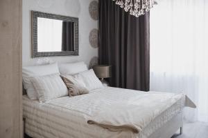 a bedroom with a bed with a mirror and a chandelier at Apartament Hubalczyków in Słupsk