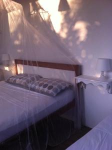um quarto com uma cama e uma rede mosquiteira em Casa da Gwen em Jericoacoara