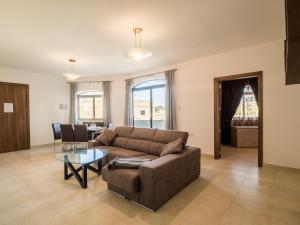 a living room with a couch and a table at Landmark Apartment in Birżebbuġa