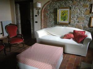 a living room with a white couch and a chair at Casale delle Due Fonti in San Venanzo