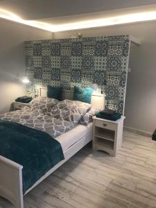 a bedroom with a large bed and a wall at Aradi Apartman in Pécs