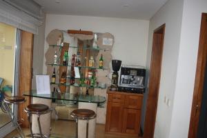 a room with a bar with a glass table and stools at Ze da Rampa Hotel in Aves