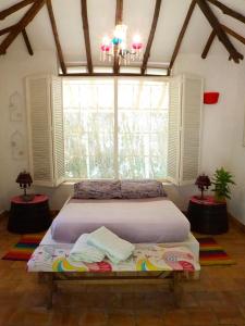 a bedroom with a bed in front of a window at La Cabana de los Novios By Casas del Sur in Barichara